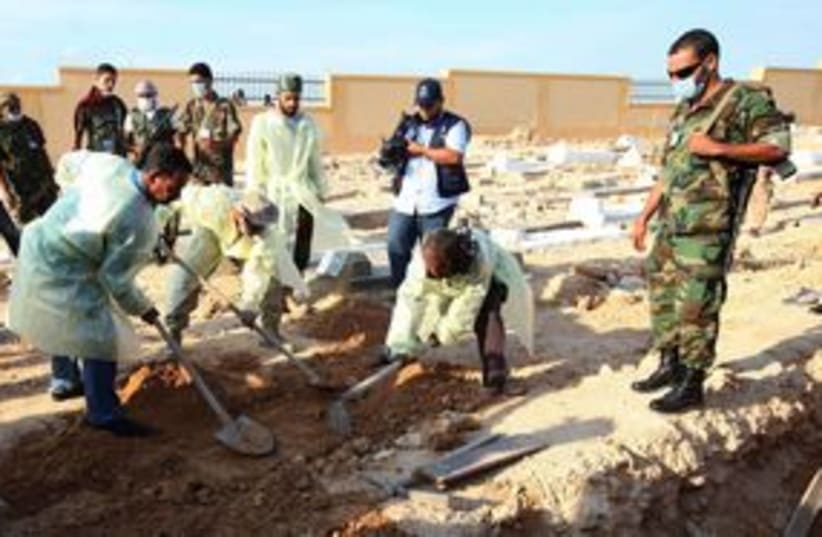 Medical, militia officials dig for bodies in Tripoli 311 (R) (photo credit: REUTERS/Ismail Zitouny)