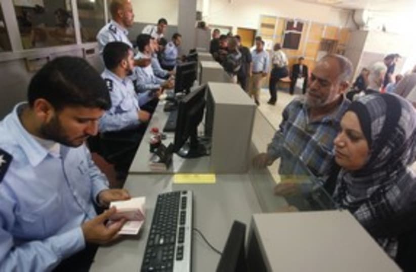 Hamas policeman checks passport at Rafah border 311 (R) (photo credit: Suhaib Salem / Reuters)
