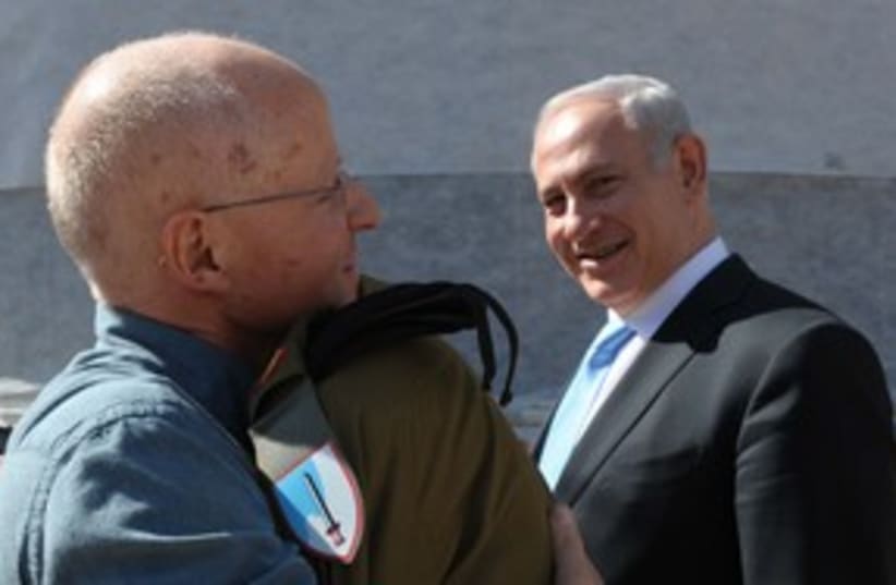 Gilad Schalit hugs father Noam, PM in background 311  (photo credit: GPO)