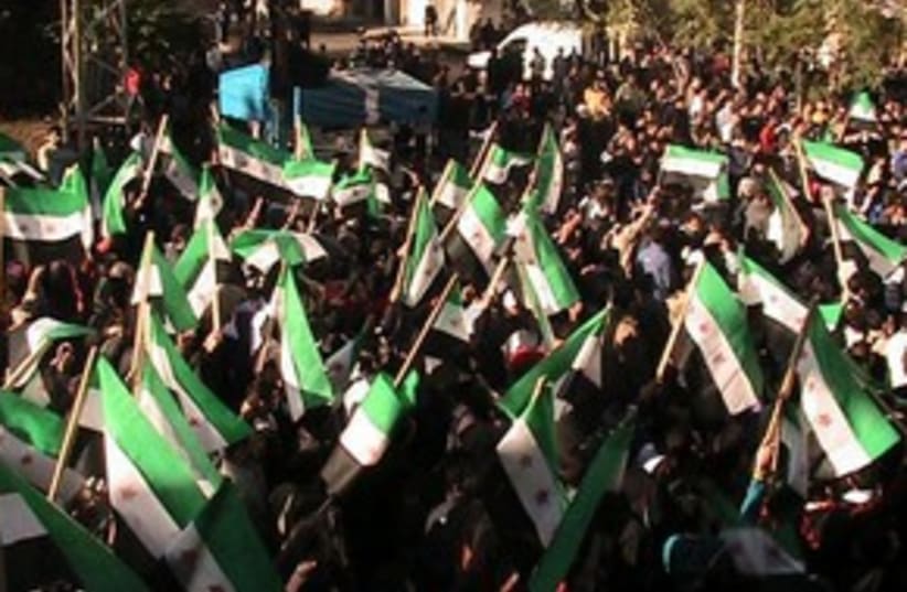 Syrian protesters with old Syrian flags 311 (R) (photo credit: REUTERS/Handout)