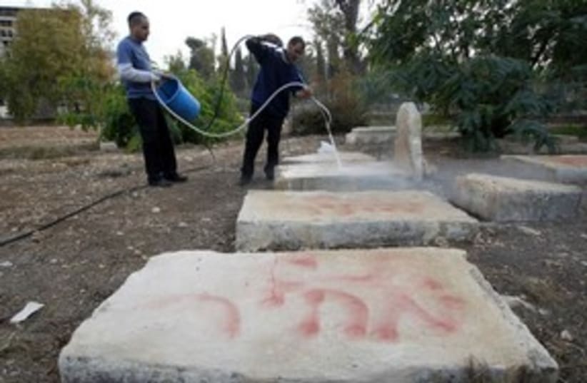 Workers clean price tag from Muslim cemetary, J'lem_311 (photo credit: Reuters)