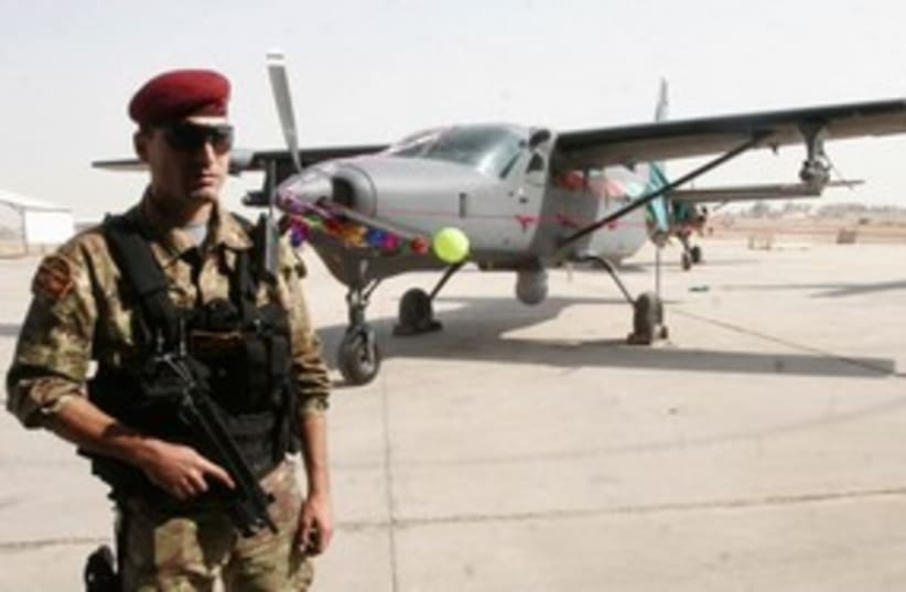 Iraqi soldier guards fighter plane 311 R (photo credit: REUTERS/STRINGER Iraq)