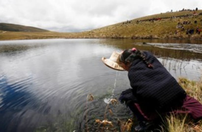 Andean woman drinks water from Cortada lagoon 311 (R) (photo credit: REUTERS/Enrique Castro-Mendivil)