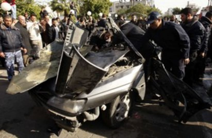 Hamas security forces survey car hit in IAF strike_311 (photo credit: Reuters/Ibraheem Abu Mustafa)