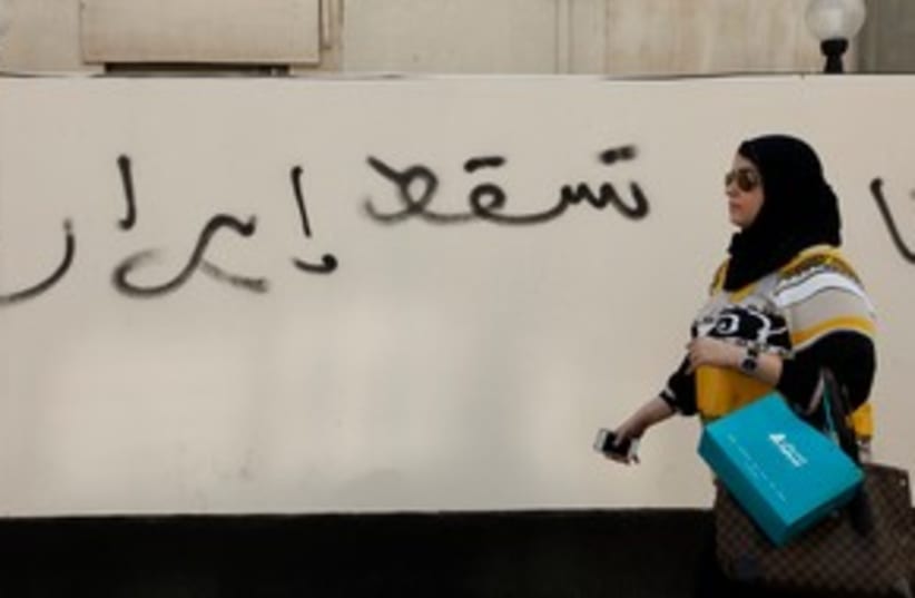 woman walks past anti Iran graffiti 311 (R) (photo credit: REUTERS/ Hamad I Mohammed)