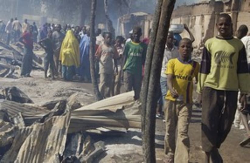 Nigerians walk by after fire razes market 311 (photo credit: REUTERS)