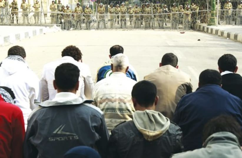 Muslims pray in front of soldiers, Egypt_521 (photo credit: Reuters)