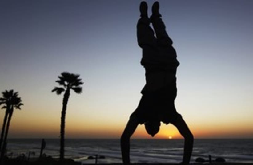 Youth does a handstand on the beach in Netanya 311 (photo credit: Reuters)
