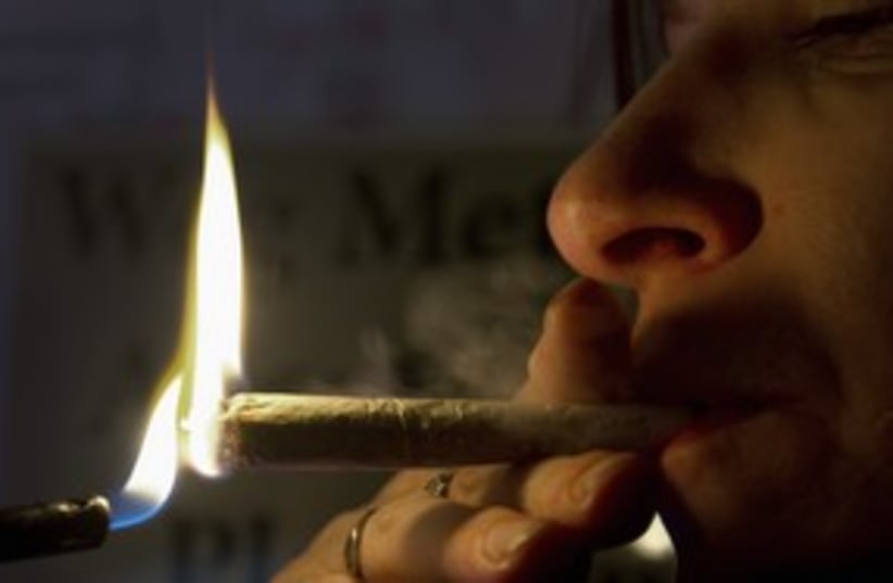 A woman smokes marijuana joint pot ganga toke 311 (R) (photo credit: Toussaint Kluiters / Reuters)