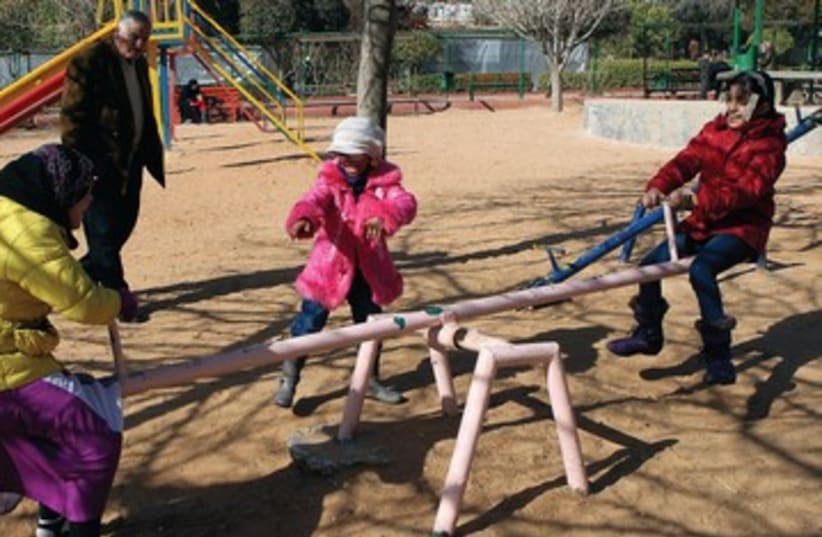 Women on see-saw with child 390 (photo credit: illustrative photo/Reuters)