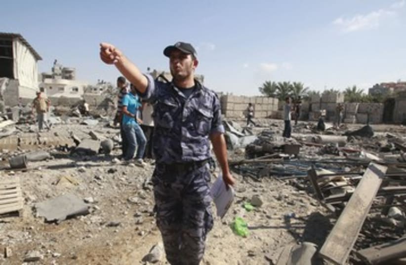 Member of Hamas security forces at site of Israeli stike 390 (photo credit: Suhaib Salem/Reuters)