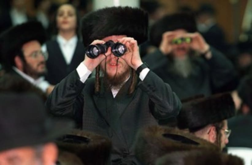 An Orthodox Jew looks through binoculars 390 (R) (photo credit: Jim Hollander / Reuters)