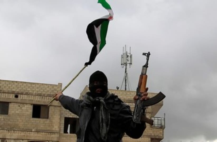 A defected Syrian soldier holds a rifle and flag 390 (R) (photo credit: REUTERS/Ahmed Jadallah )