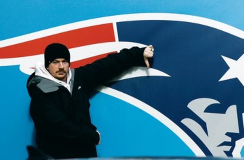 FAN poses in front of a New England Patriots logo 390 (photo credit: REUTERS)