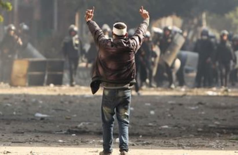 Protester gestures at police during Cairo clashes 390 (R) (photo credit: REUTERS/Suhaib Salem)