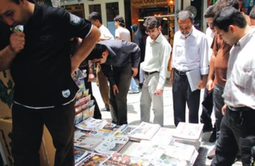 Iranians read newspapers in Tehran 390 (photo credit: Reuters)