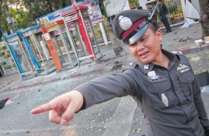 Thai policeman at the scene of Bangkok bombing 390 (R) (photo credit: Damir Sagolij/Reuters)