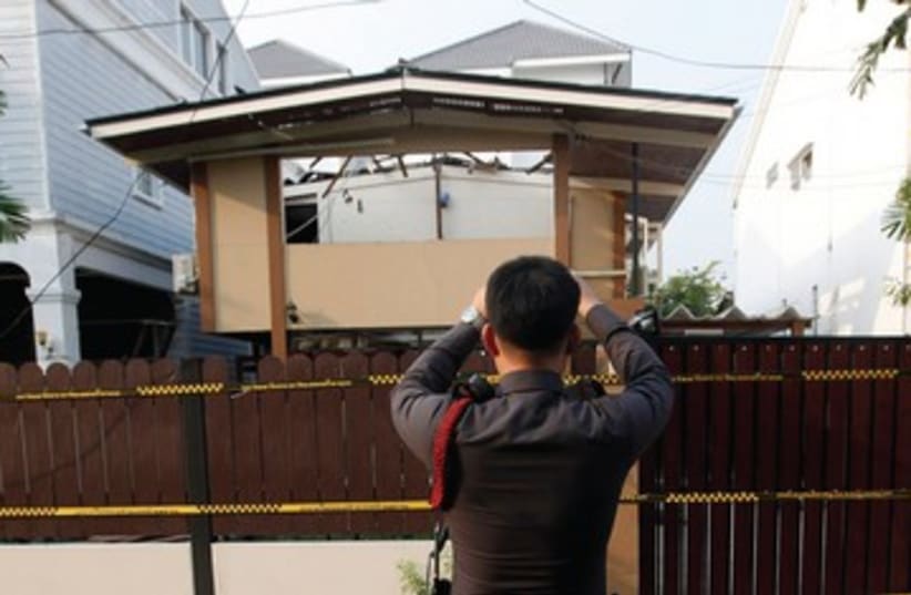 Thai policeman takes photo of terror site_390 (photo credit: Reuters)