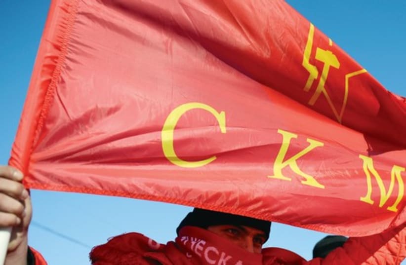 Russian protester holds up communist flag 521 (photo credit: Reuters)