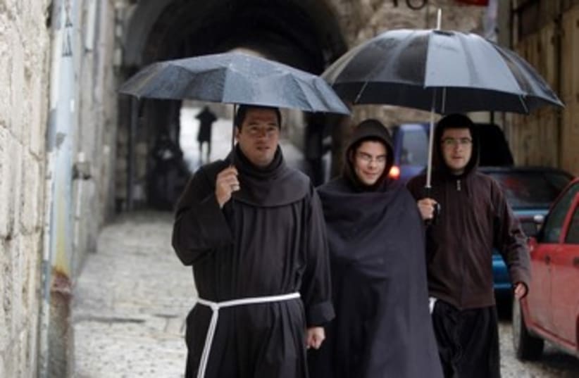Monks in rain in Jerusalem 390 (photo credit: REUTERS)
