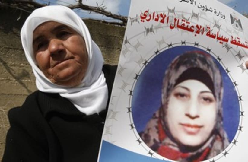 Badeeah Shalabi holds a placard of her daughter Hana 390 (photo credit: reuters)