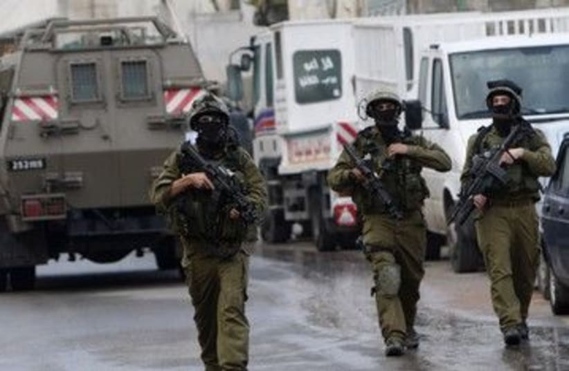 IDF soldiers patrol during a raid 390 (R) (photo credit: Abed Omar Qusini / Reuters)