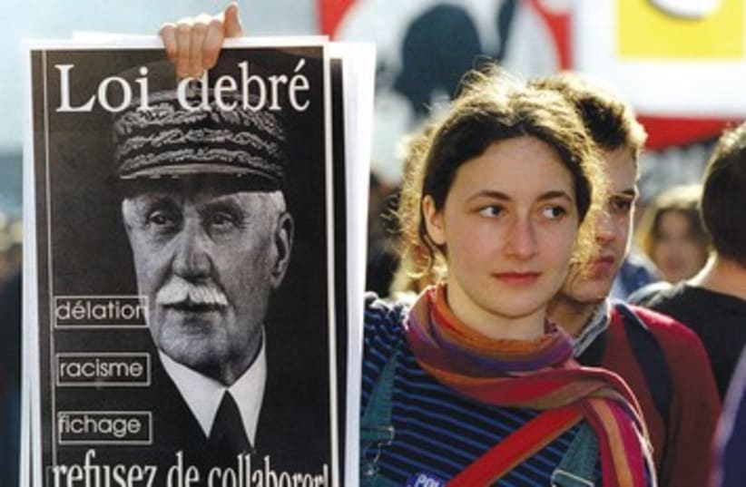 Protester holding up sign of Philippe Petain (photo credit: Reuters)