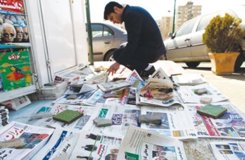 A man looks at a newspaper in Tehran R 390 (photo credit: Raheb Homavandi/Reuters)