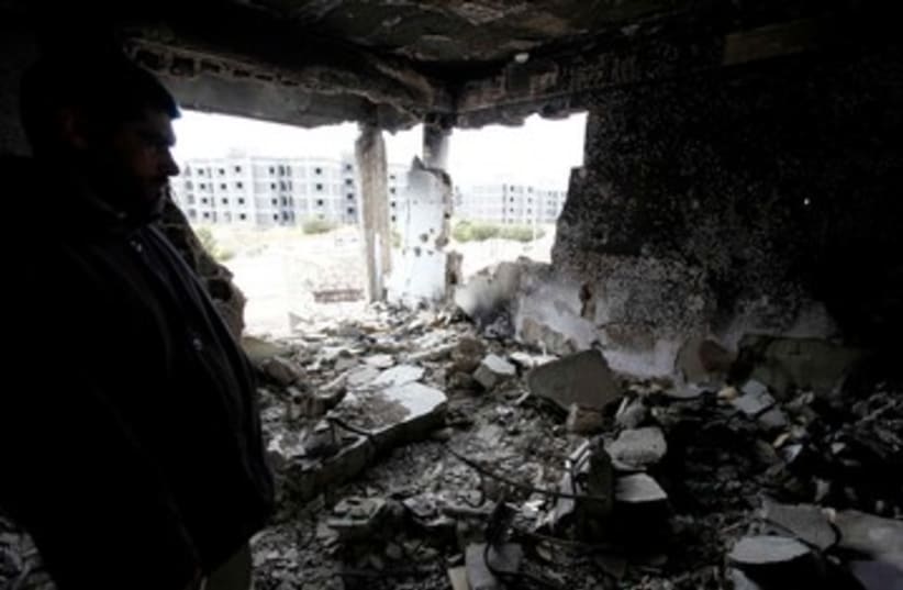 Syrian man surveys his damaged home 390 (R) (photo credit: REUTERS/Anis Mili)