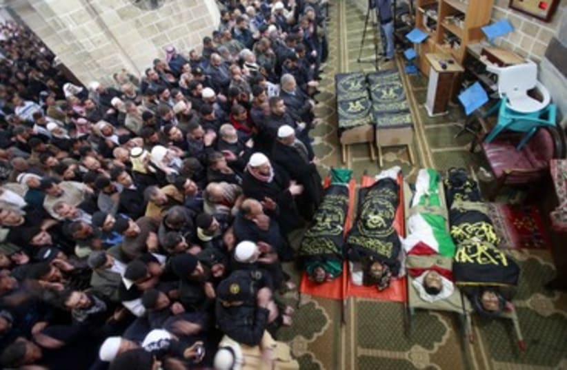 Palestinains pray near Islamic Jihad bodies_370 (photo credit: Suhaib Salem/Reuters)