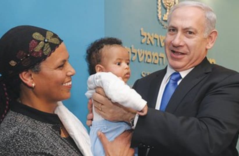 PM holds Ethiopian baby at Knesset 390 (photo credit: GPO)