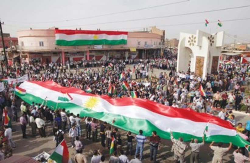 Iraqi Kurds waving flags 390 (photo credit: REUTERS)