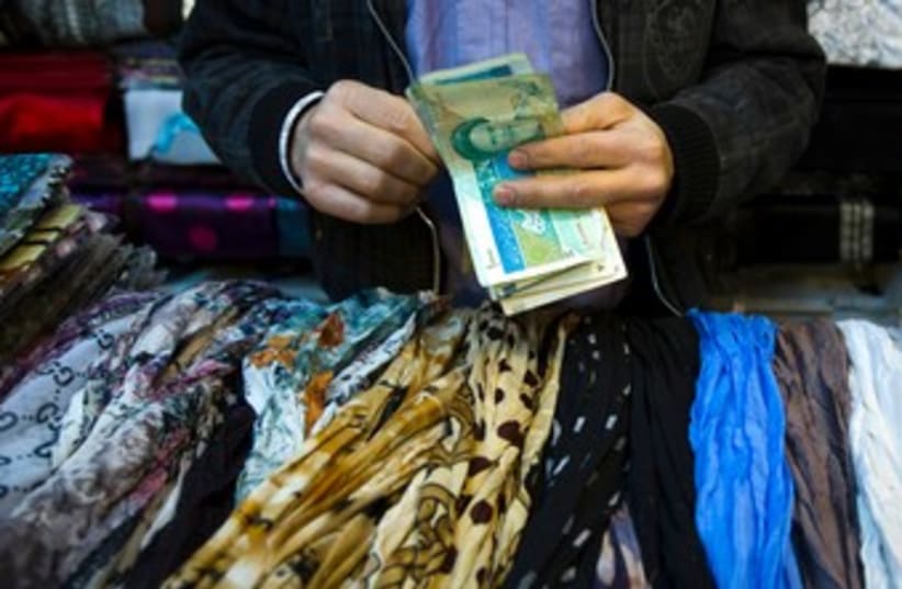 Iranian handles money at bazaar 370 (photo credit: REUTERS)