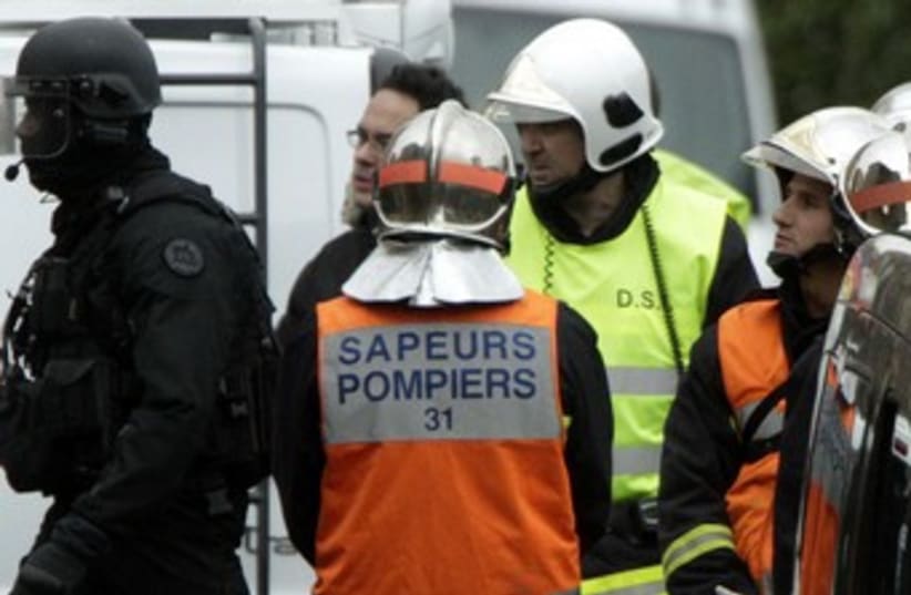 Firemen, special unit police outside French Shooter apt 370 (photo credit: REUTERS/Jean-Philippe Arles )