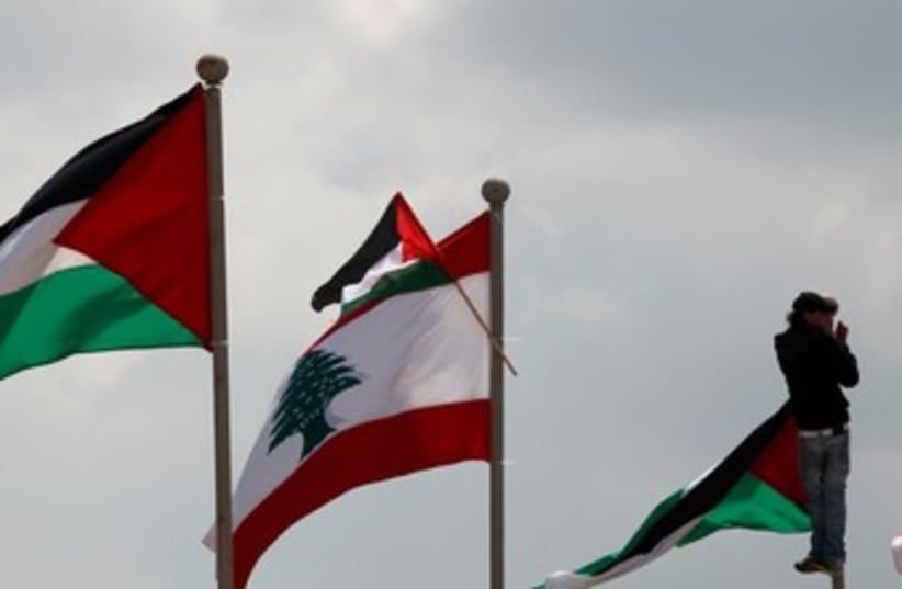 Man atop flag pole in Land Day protest in Lebanon 370 (photo credit: REUTERS)