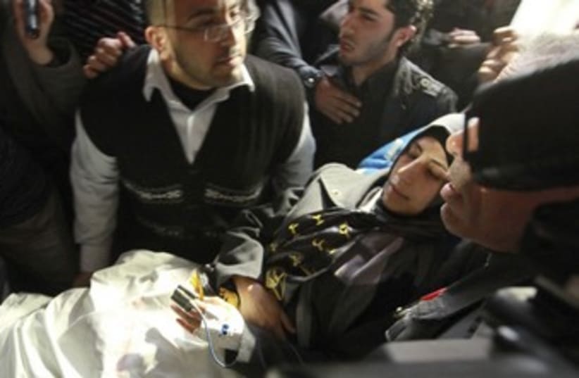 Shalabi is carried to Gaza hospital_370 (photo credit: Mohammed Salem/Reuters)