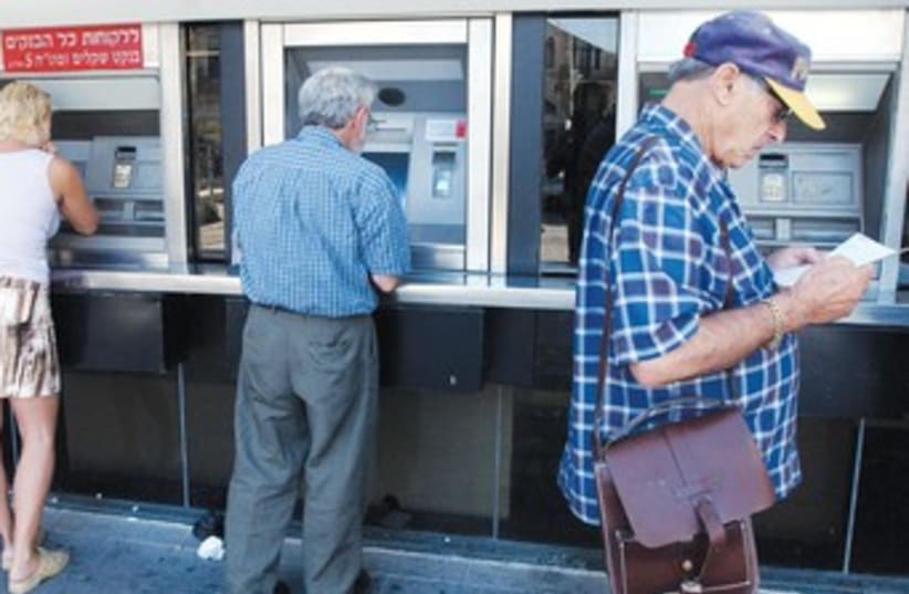 People make transactions at Bank Hapoalim ATM 370 (photo credit: Ariel Jerozolimski)