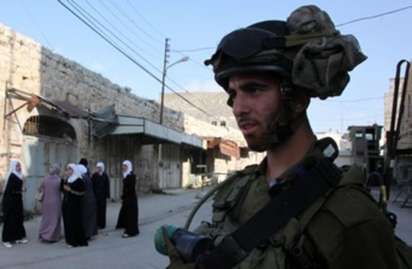 Soldier, Arab women in Hebron_370 (photo credit: Marc Israel Sellem/The Jerusalem Post)
