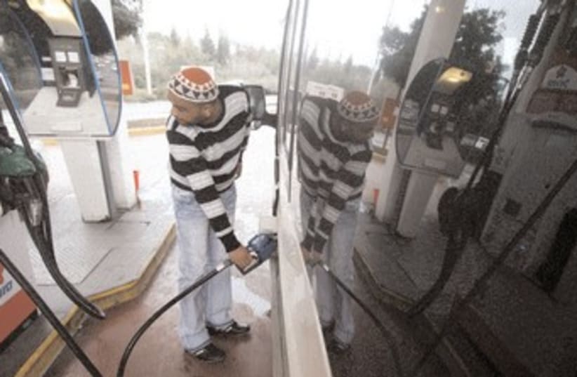 A man pumping gasoline at a gas station 370 (R) (photo credit: Reuters)
