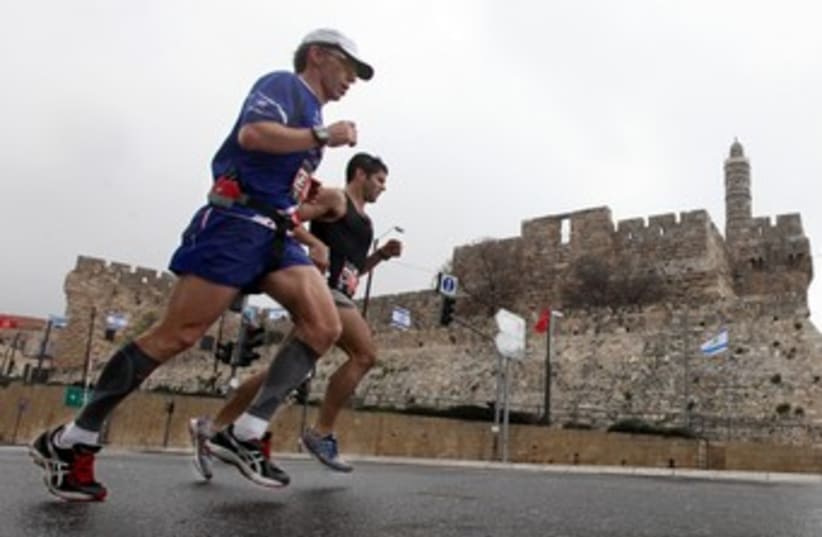 Runners in Jerusalem Marathon pass Old City 370 (photo credit: Marc Israel Sellem)