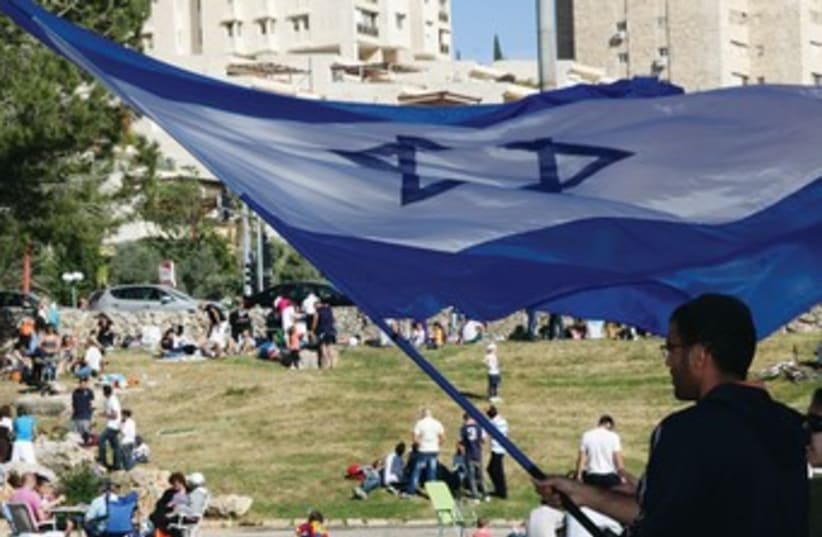 Man waves Israeli flag in Jerusalem 370 (photo credit: Marc Israel Sellem)