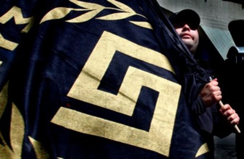 Golden Dawn party activist waves flag with party logo 370 (photo credit: REUTERS/Yannis Behrakis)