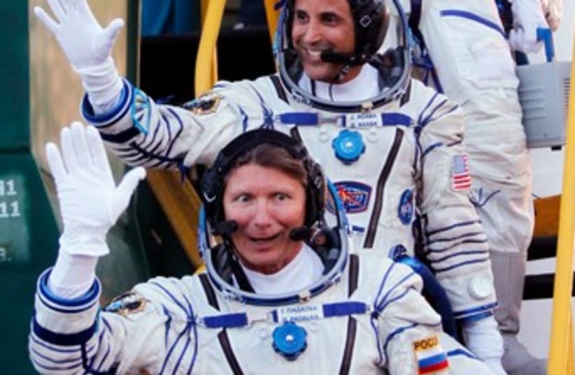 Astronauts suit up (photo credit: REUTERS/Yuri Kochetkov/Pool )