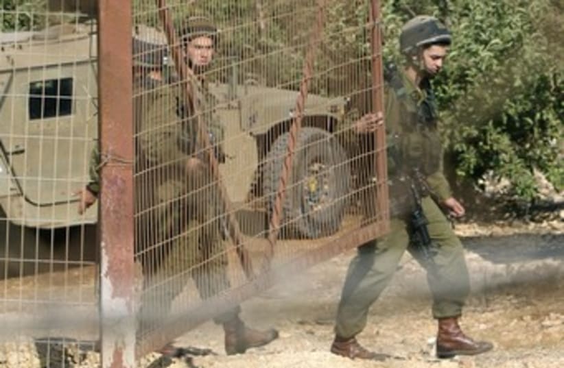IDF soldiers close gate at Lebanon Border 370 (photo credit: Jamal Saidi / Reuters)