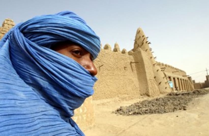 Tuareg nomad stands near 13th century mosque at Timbuktu 370 (photo credit: REUTERS)