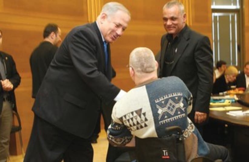 Binyamin Netanyahu shakes hands with a disabled veteran 370 (photo credit: Ariel Jerozolimski)