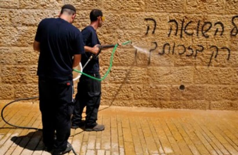 Workers cleaning graffiti at Yad Vashem 370 (photo credit: Hadas Parush)
