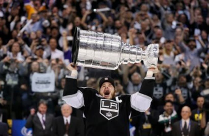 Kings right wing Dustin Brown hoists the Stanley Cup 370 (R) (photo credit: REUTERS/Lucy Nicholson)