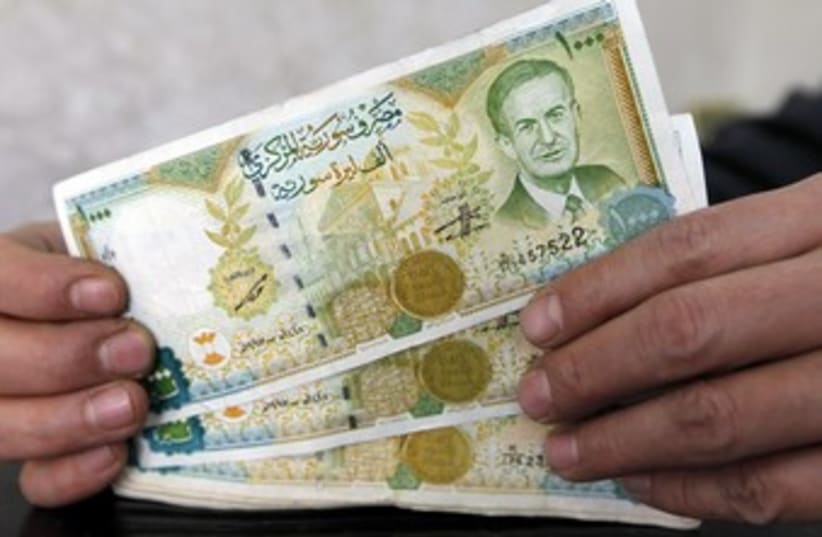 A money changer displays Syrian pounds 370 (R) (photo credit: Murad Sezer / Reuters)