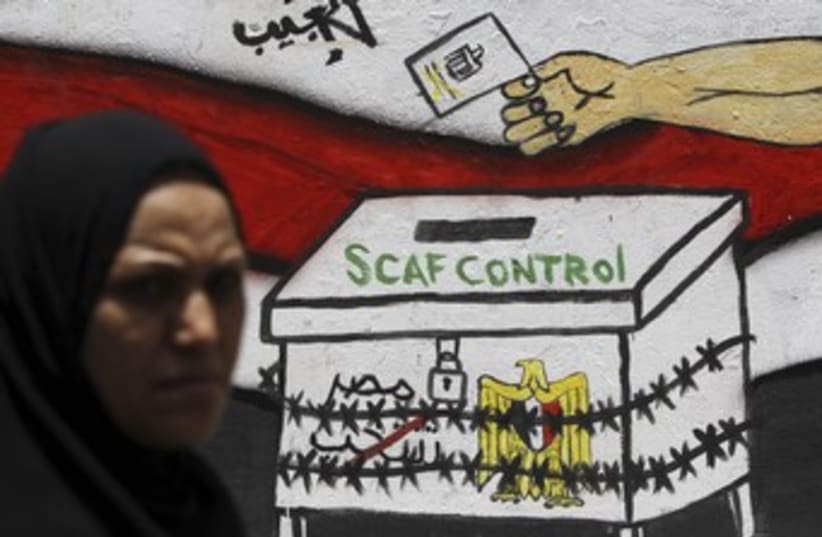 Egyptian walks past 'SCAF Control' graffiti 370 (R) (photo credit: Amr Dalsh / Reuters)